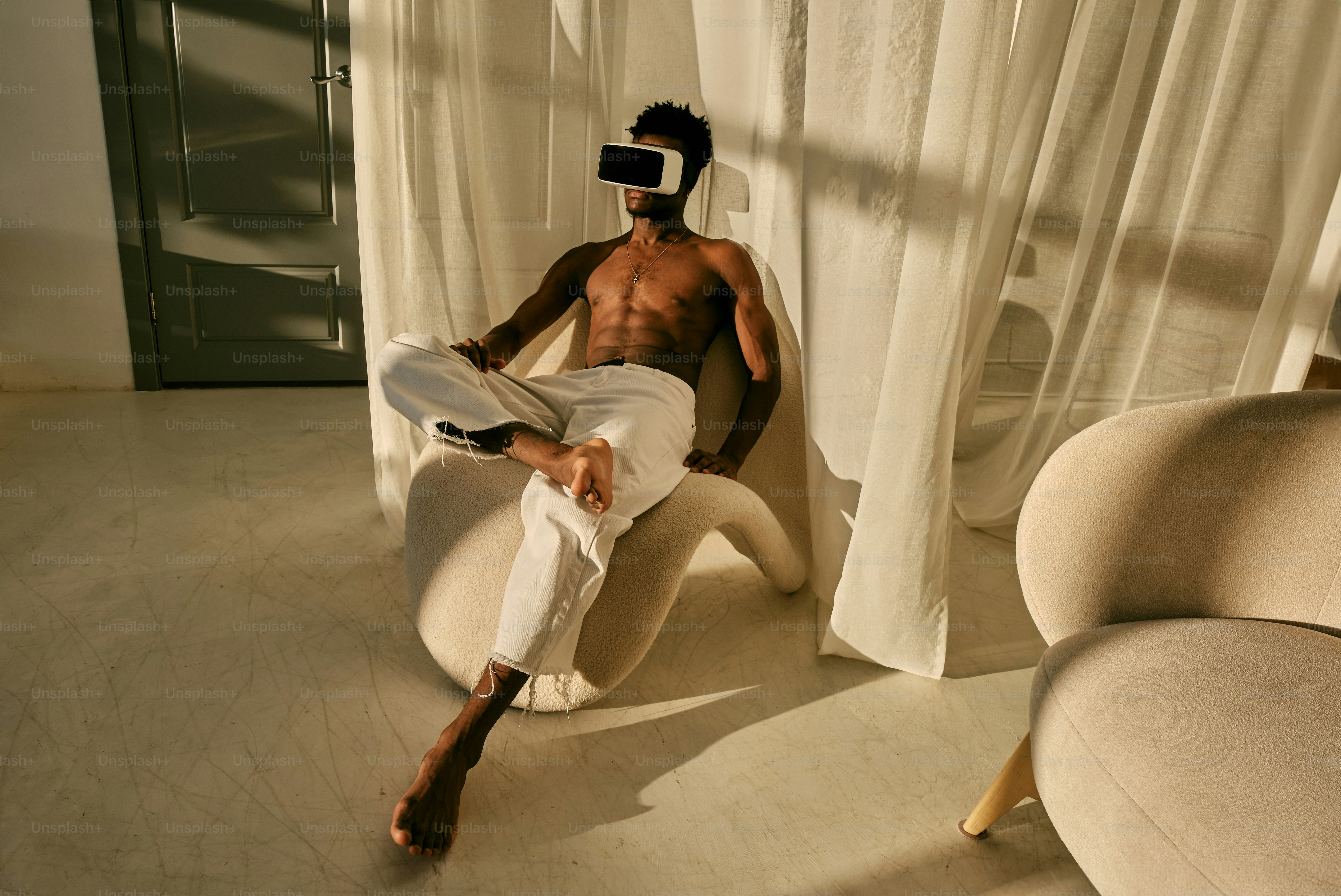 a shirtless man sitting on a chair in a room