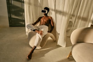 a shirtless man sitting on a chair in a room