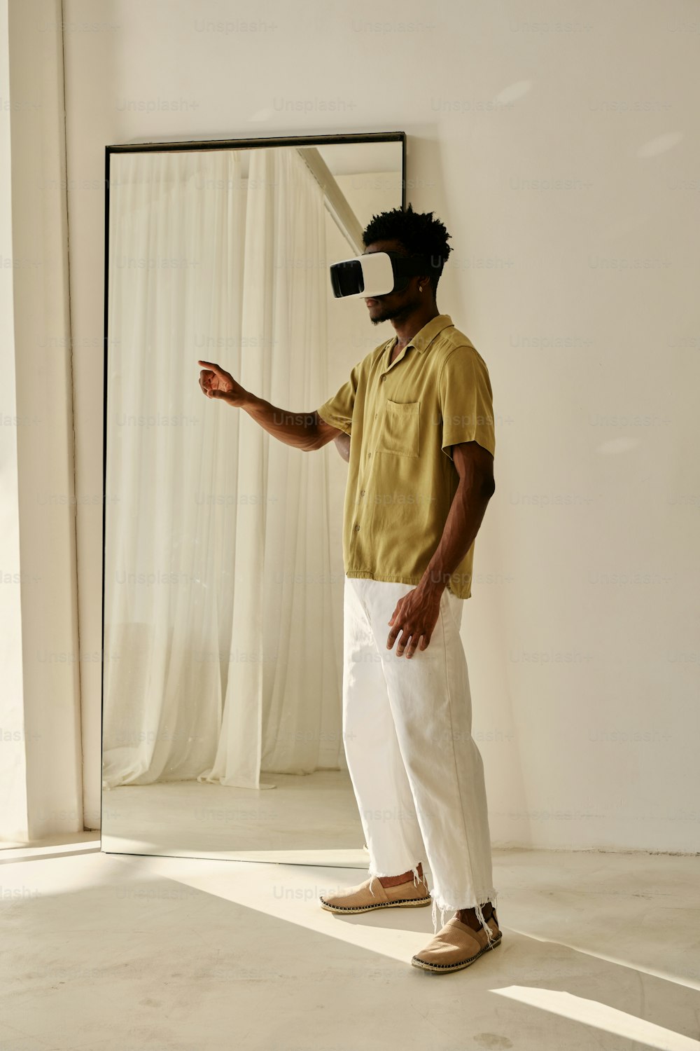 um homem parado em frente a um espelho usando um fone de ouvido de realidade virtual