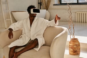 a man sitting on a couch wearing a white robe