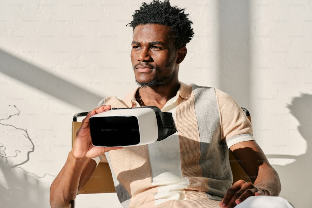 a man sitting in a chair holding a device