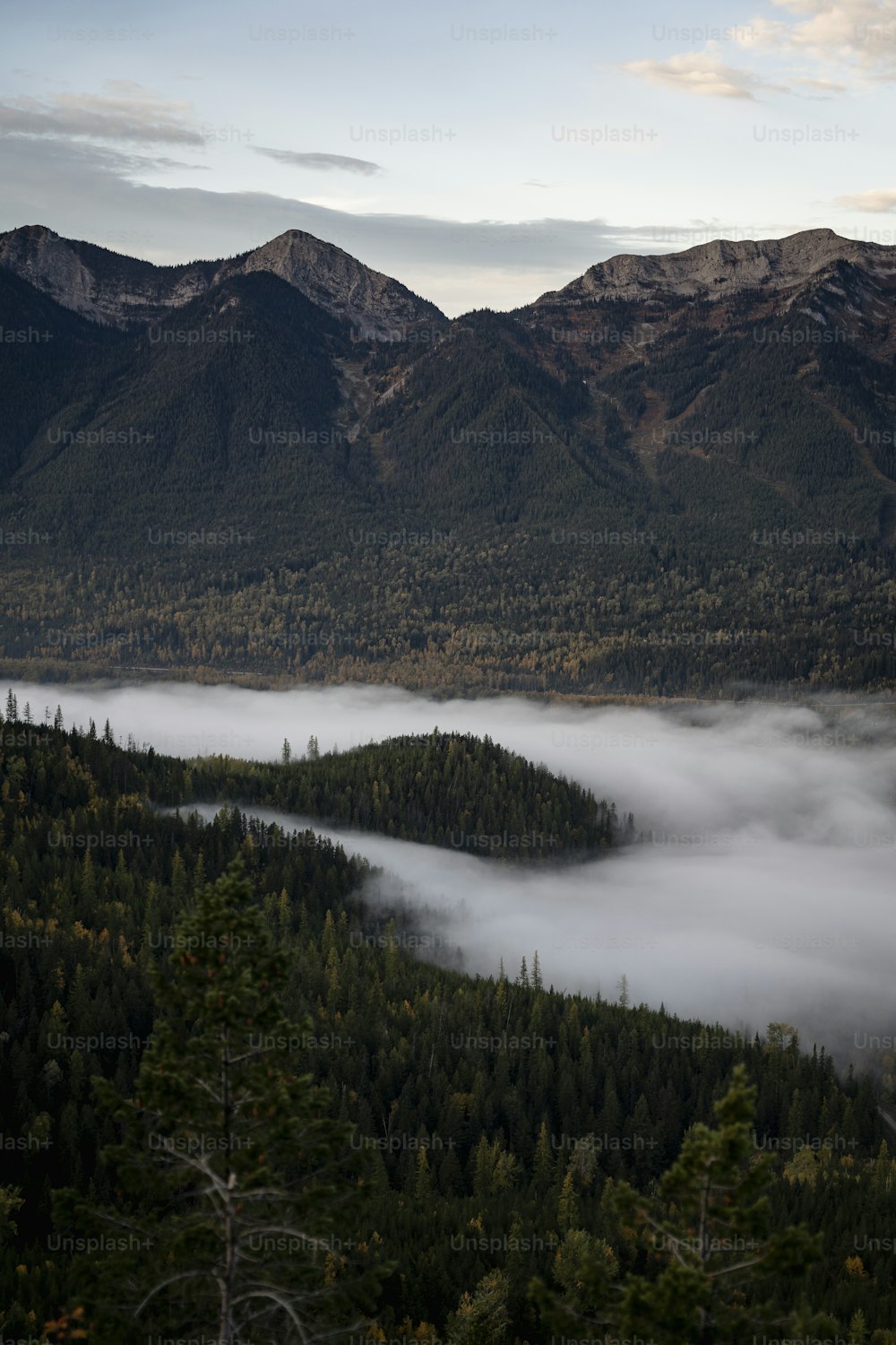 a view of a mountain range covered in low lying clouds