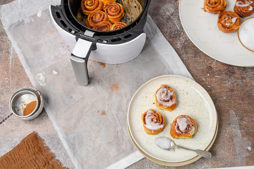 a plate of cinnamon rolls next to a slow cooker