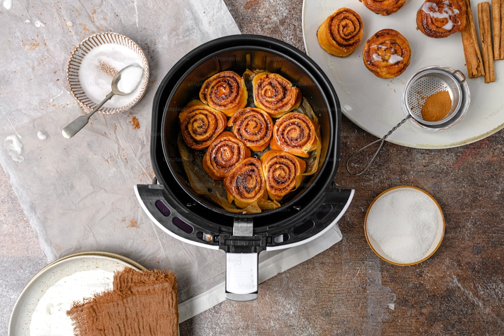a crock pot filled with cinnamon rolls on top of a table