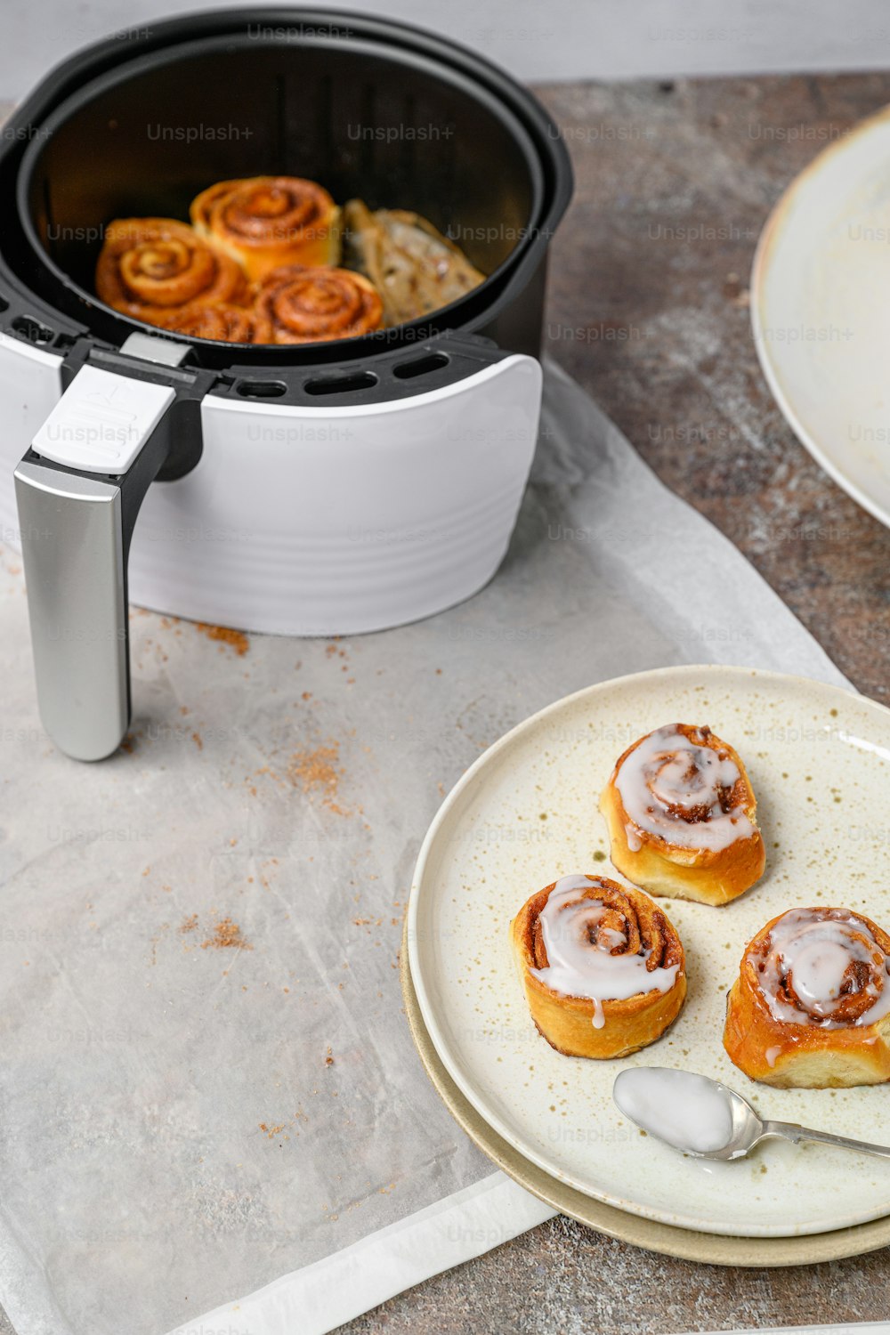 a plate of cinnamon rolls next to a slow cooker
