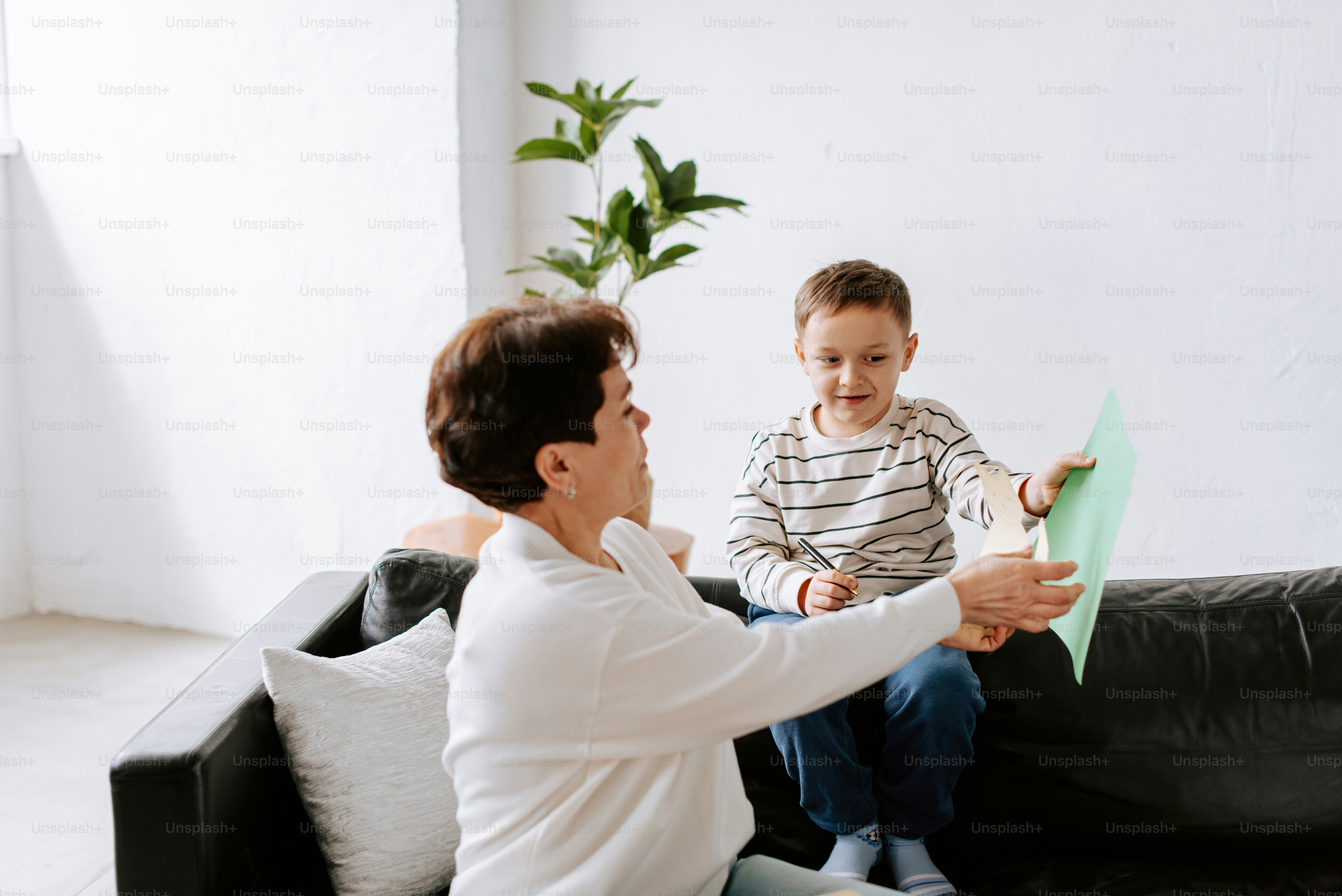 eine Frau, die mit einem Kind auf einer Couch sitzt