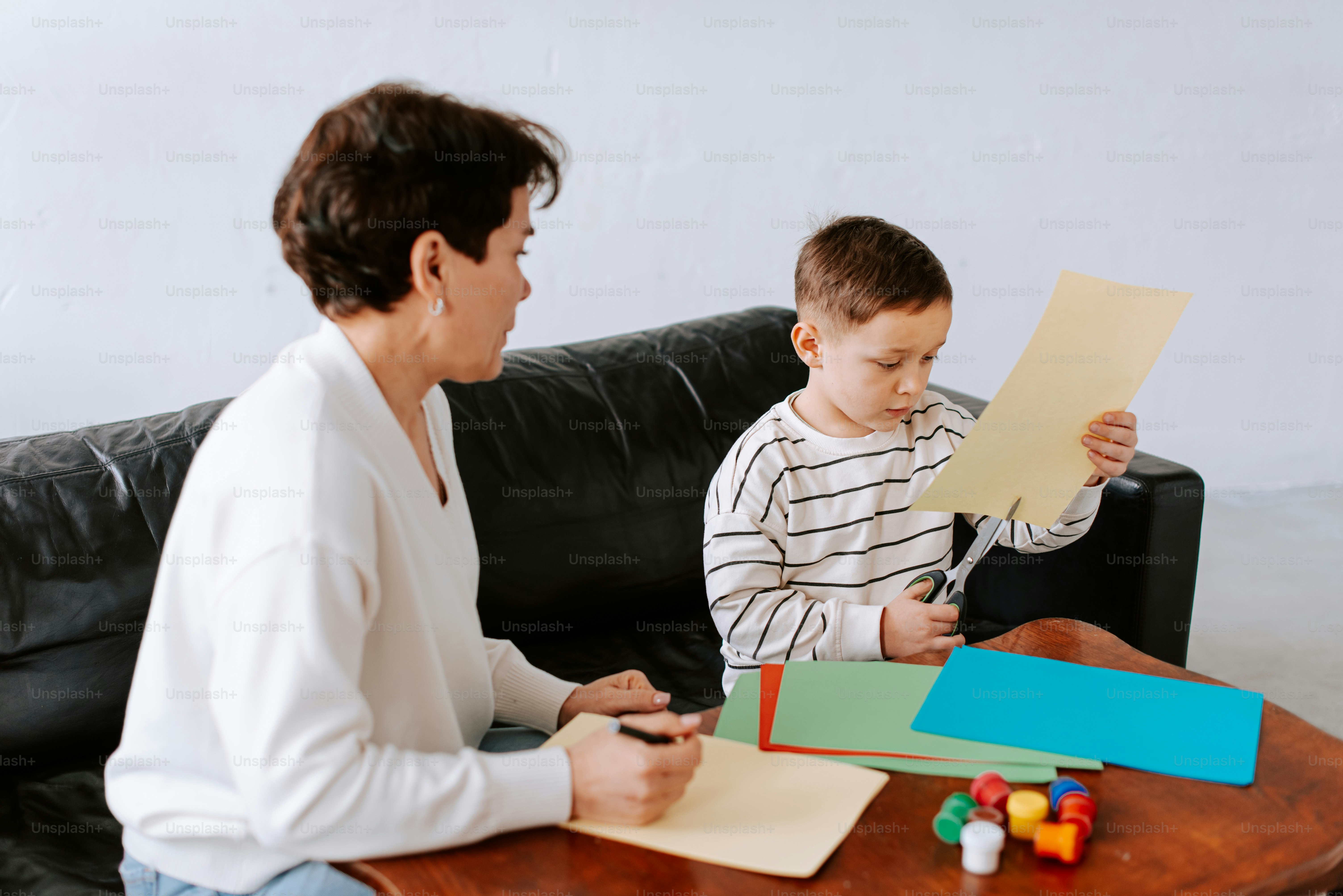 Eine Frau sitzt neben einem Jungen auf einer Couch