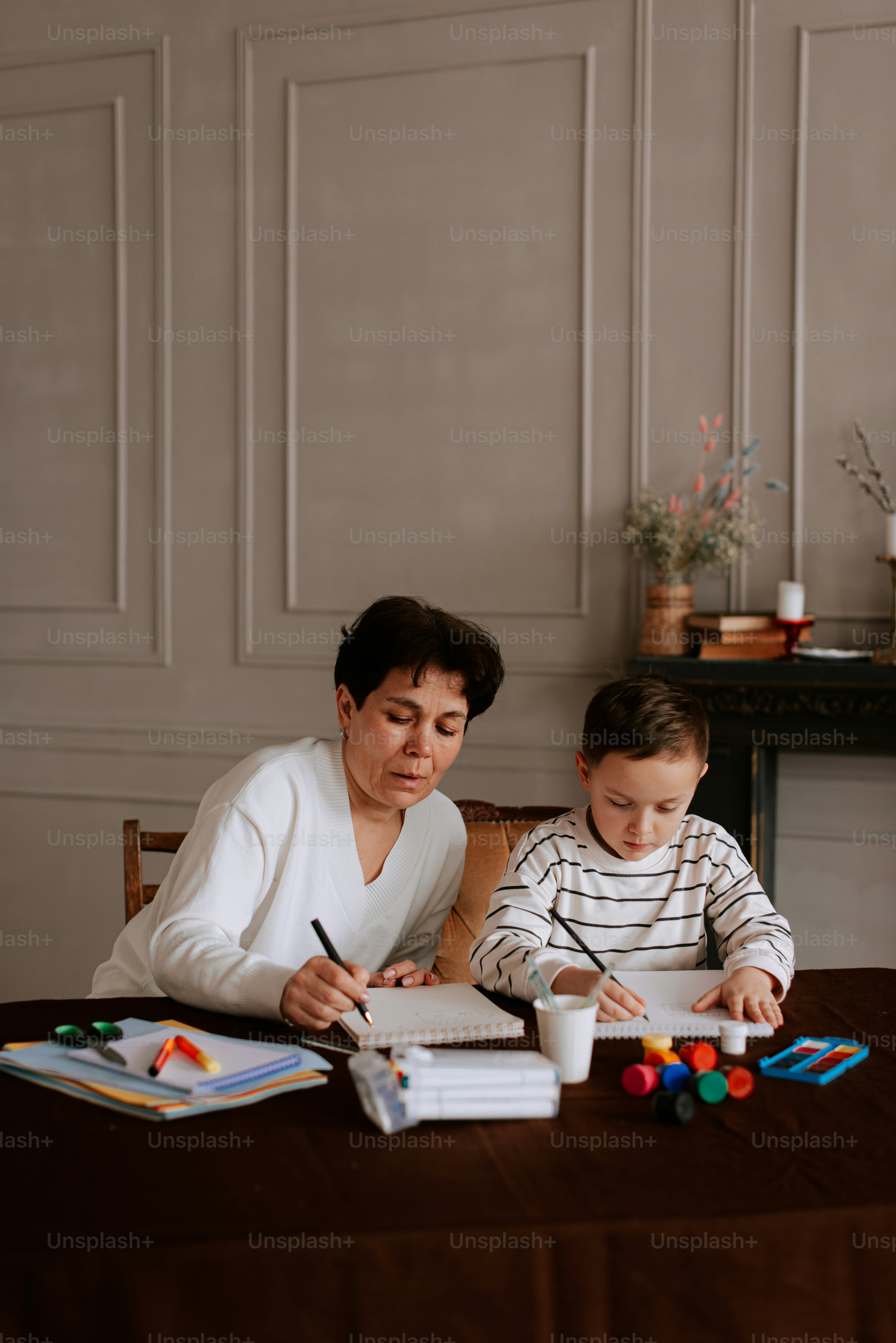 eine Frau sitzt mit einem Kind an einem Tisch