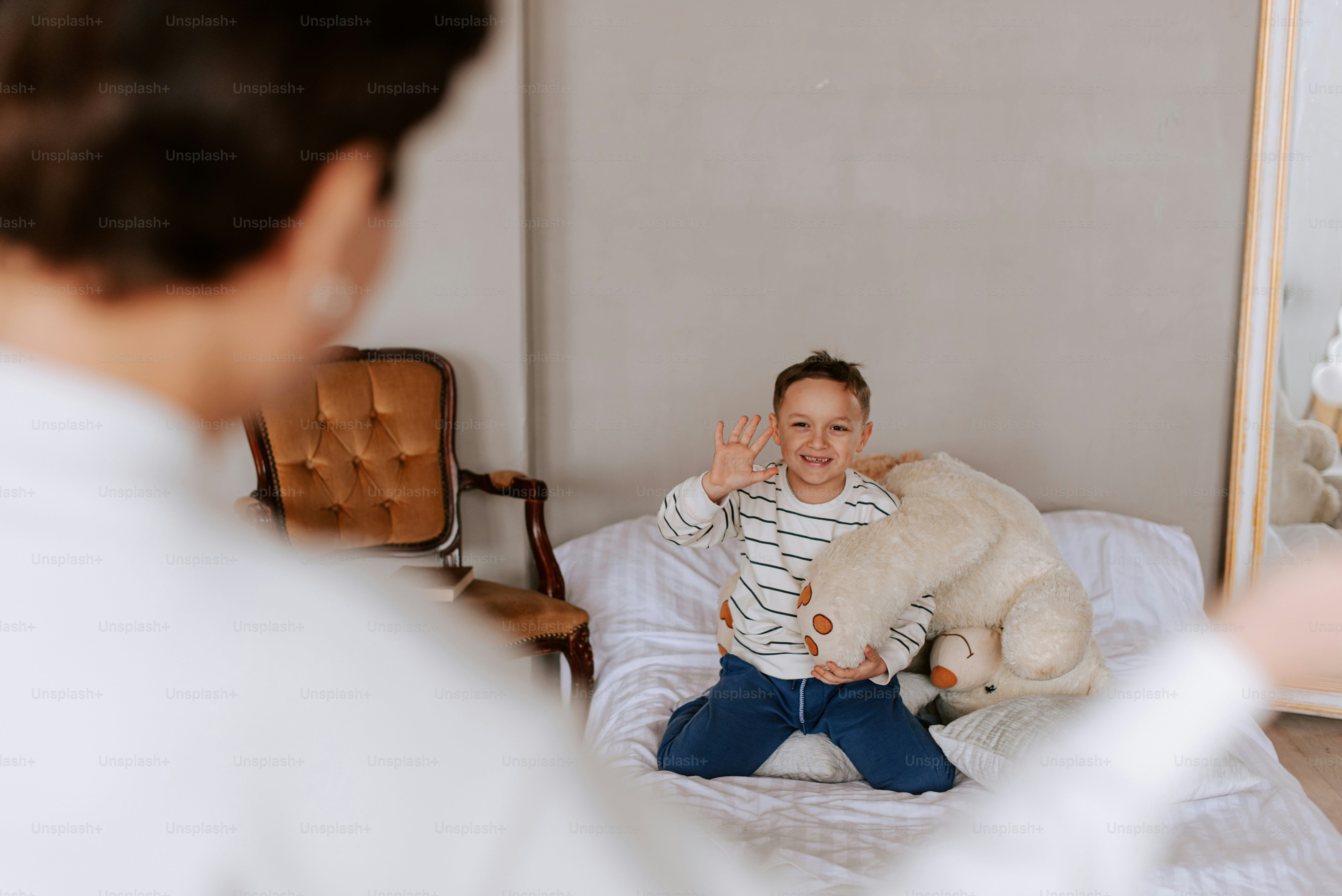 eine Frau, die auf einem Bett sitzt und einen Teddybären hält