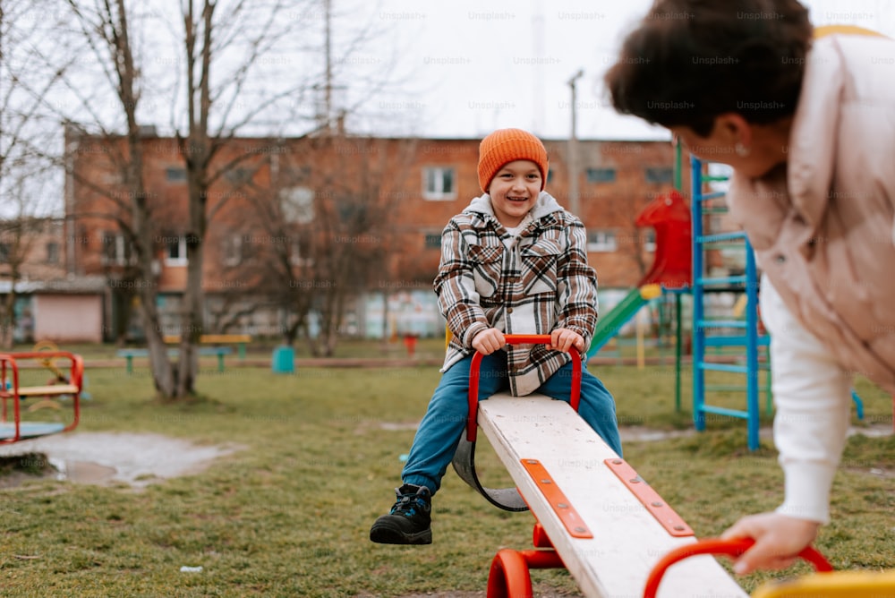 a young boy sitting on top of a wooden bench