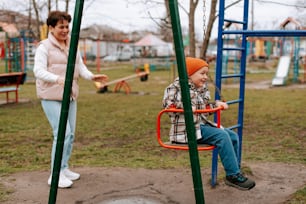 una mujer y un niño jugando en un parque