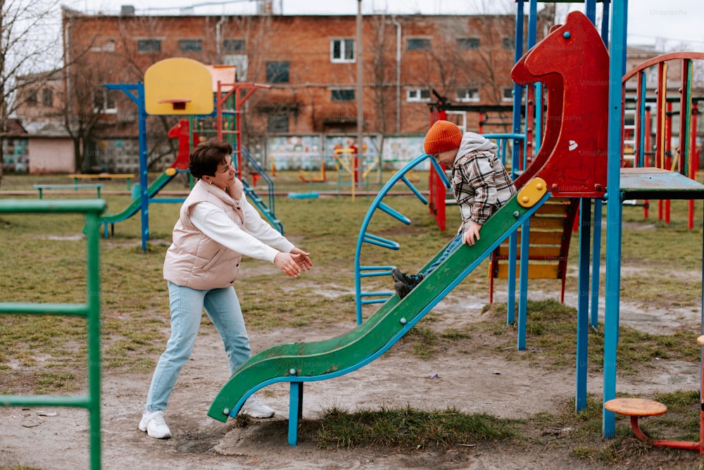 un homme et une femme jouant sur une aire de jeux