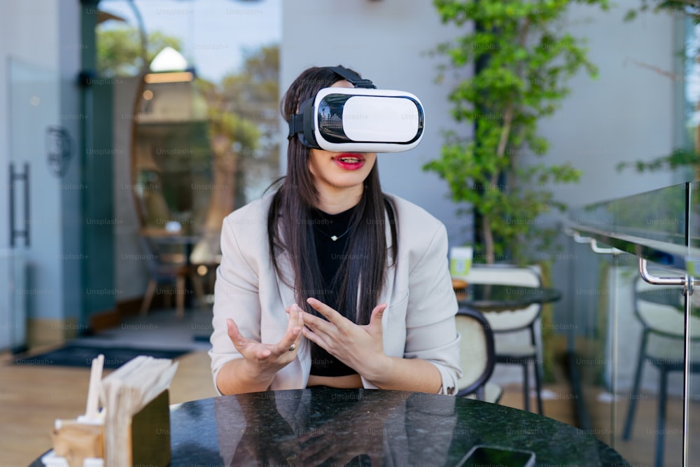 a woman wearing a virtual headset sitting at a table