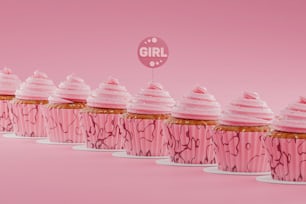 a row of pink cupcakes with white frosting