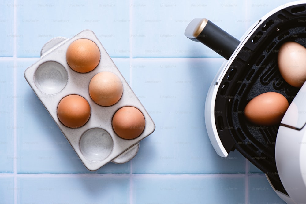 a group of eggs in a carton next to a toaster