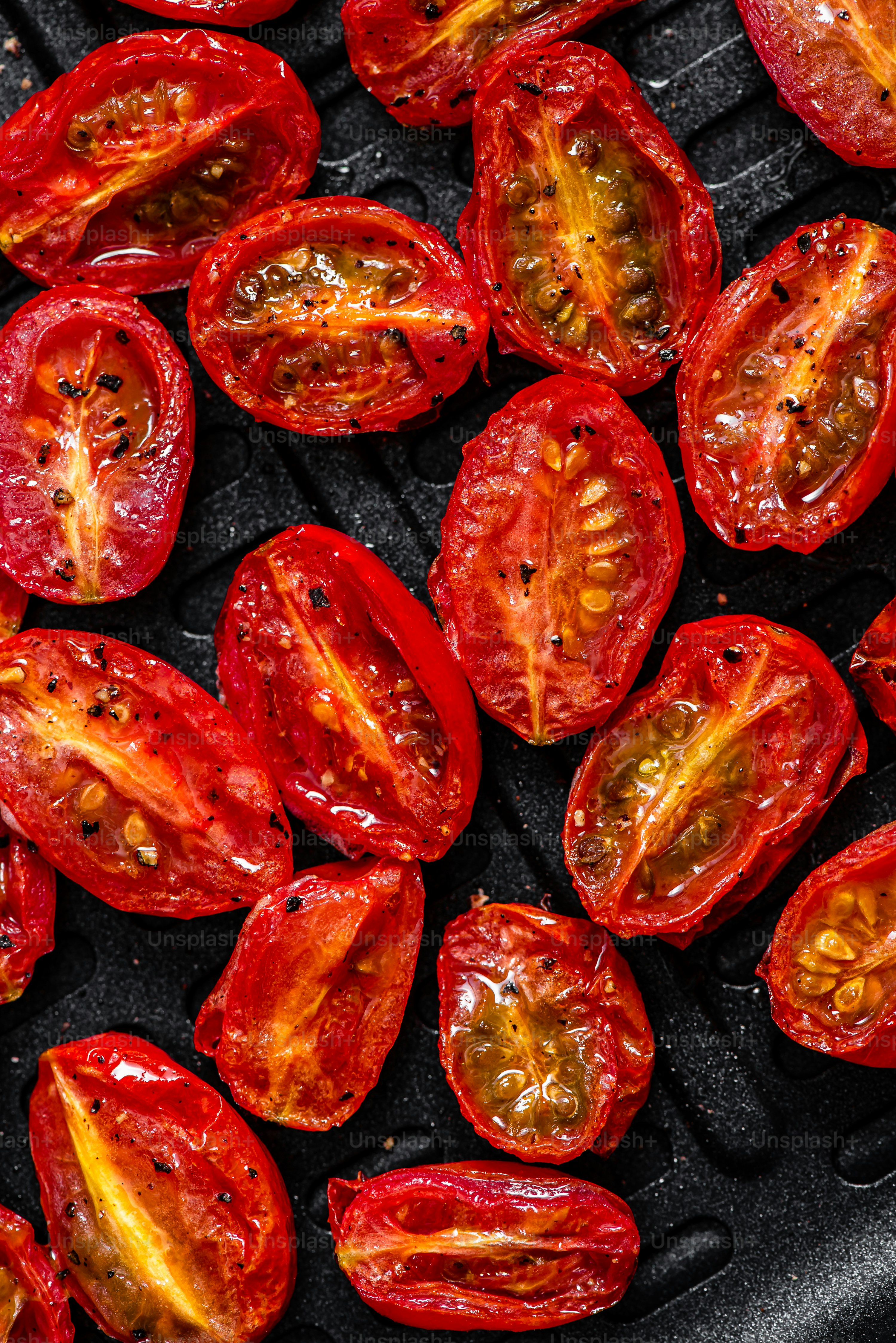 a close up of a bunch of tomatoes on a grill