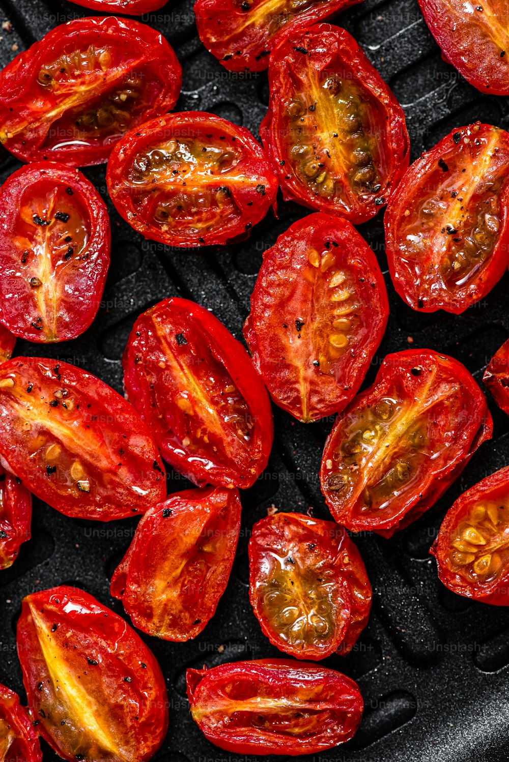 a close up of a bunch of tomatoes on a grill
