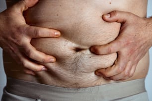 Un primer plano de una persona sosteniendo su estómago