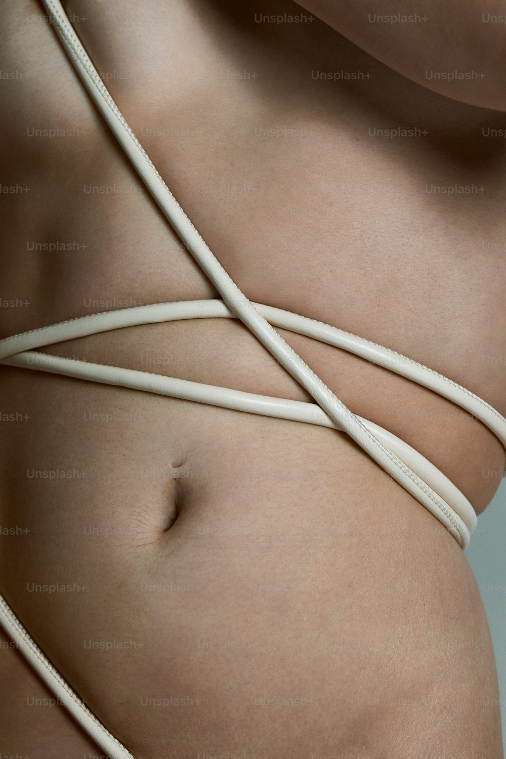 Un primer plano del estómago de una mujer con una cuerda envuelta alrededor de él