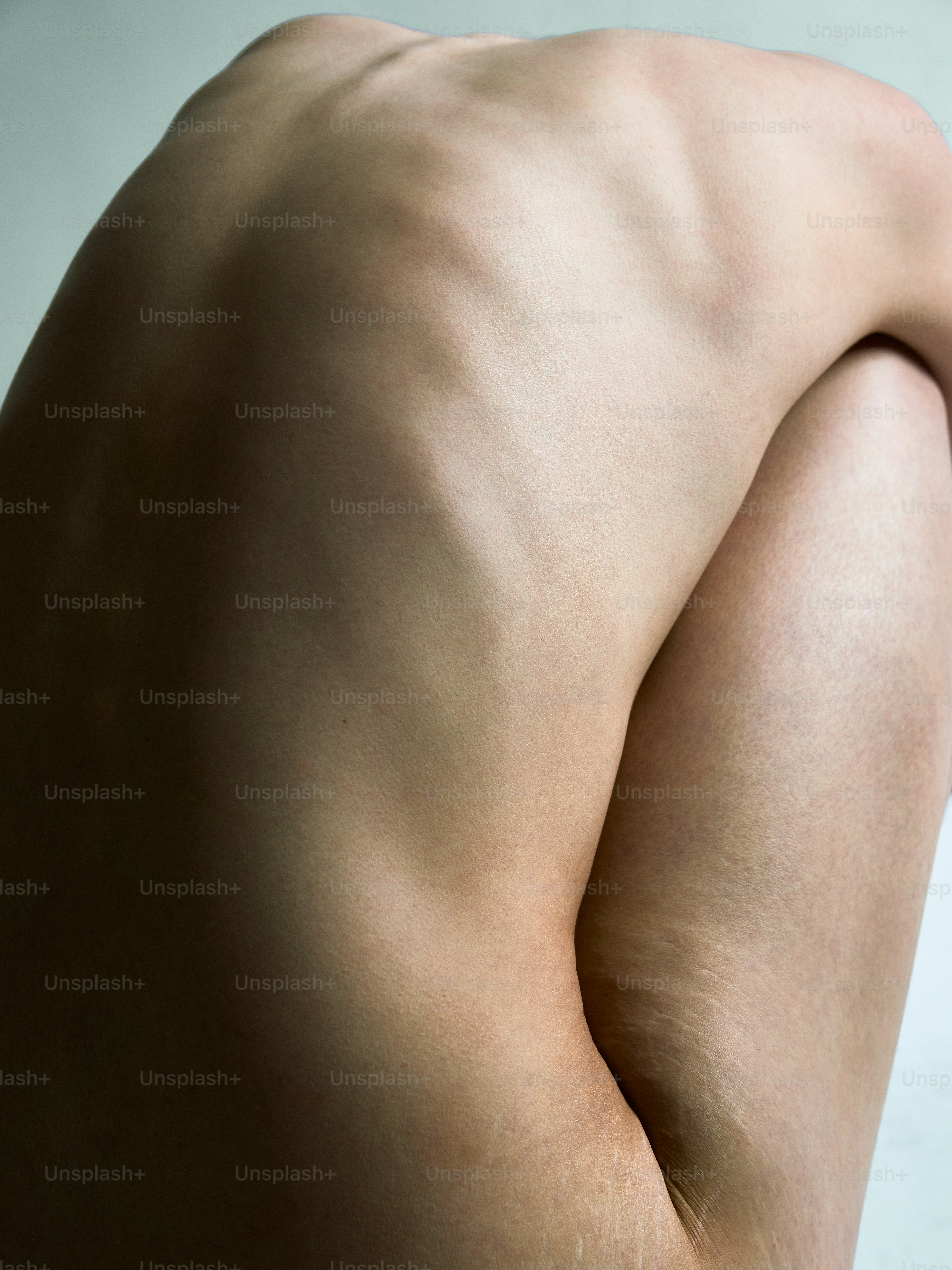 a naked man with no shirt standing in front of a white wall