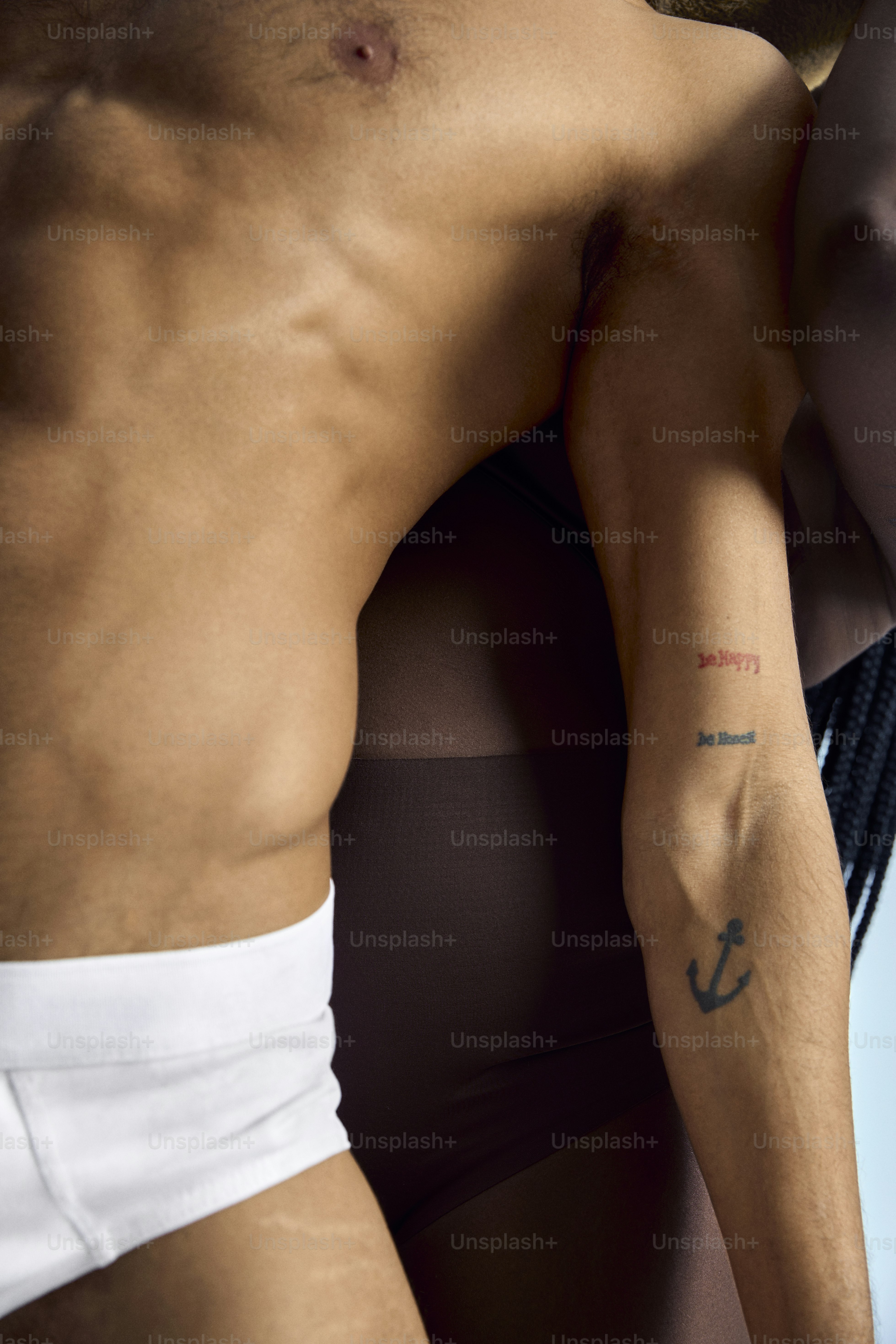 a man with a small anchor tattoo on his arm