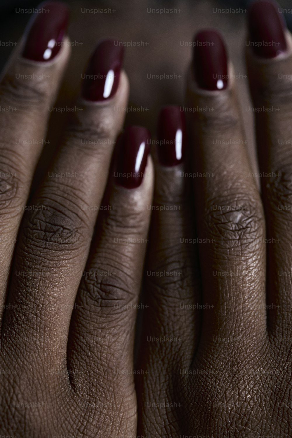 a close up of a person's hand with a red manicure