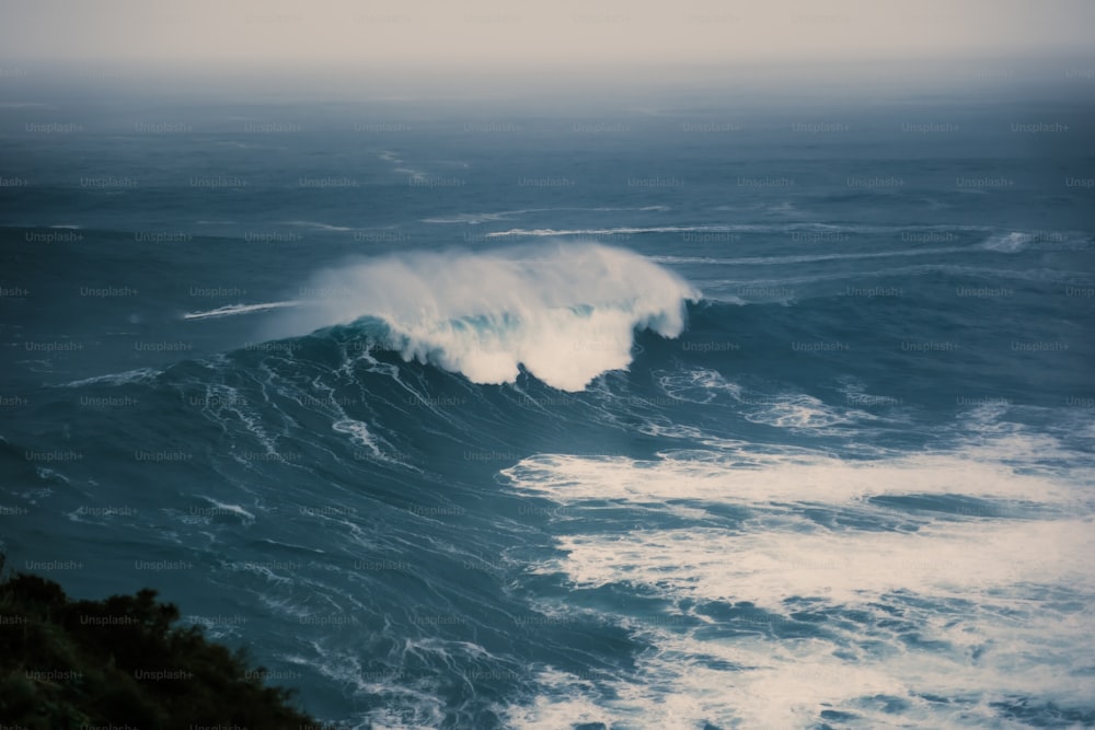 una gran ola rompiendo en el océano en un día nublado