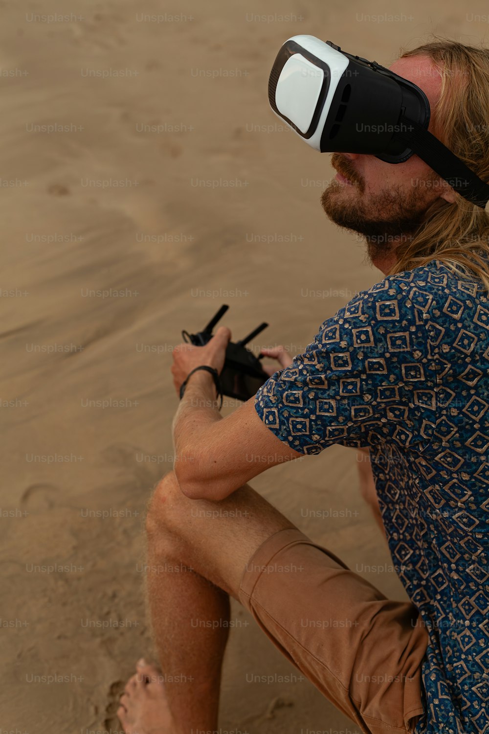 a man sitting on a beach wearing a pair of virtual glasses