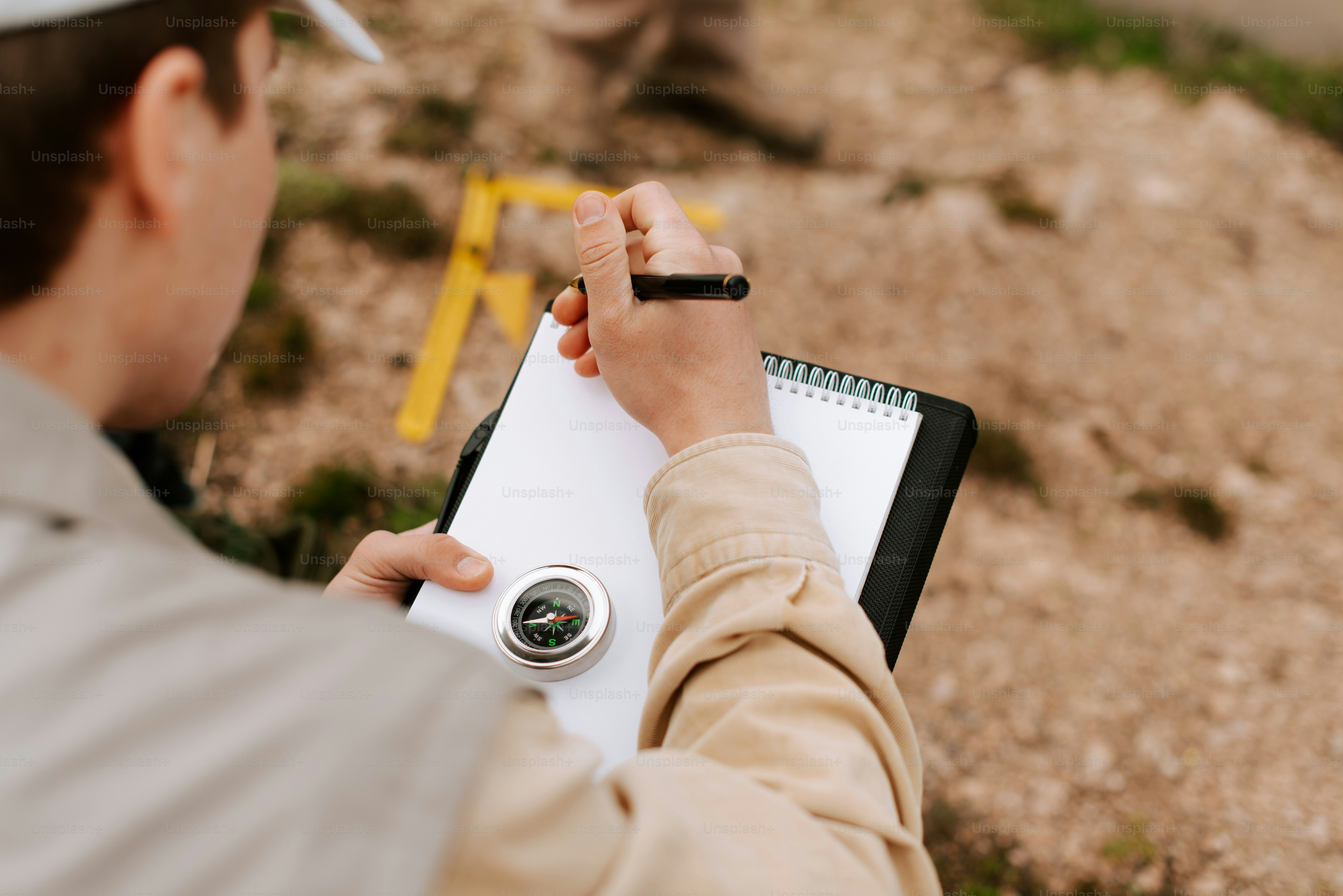 un hombre escribiendo en un cuaderno con un bolígrafo