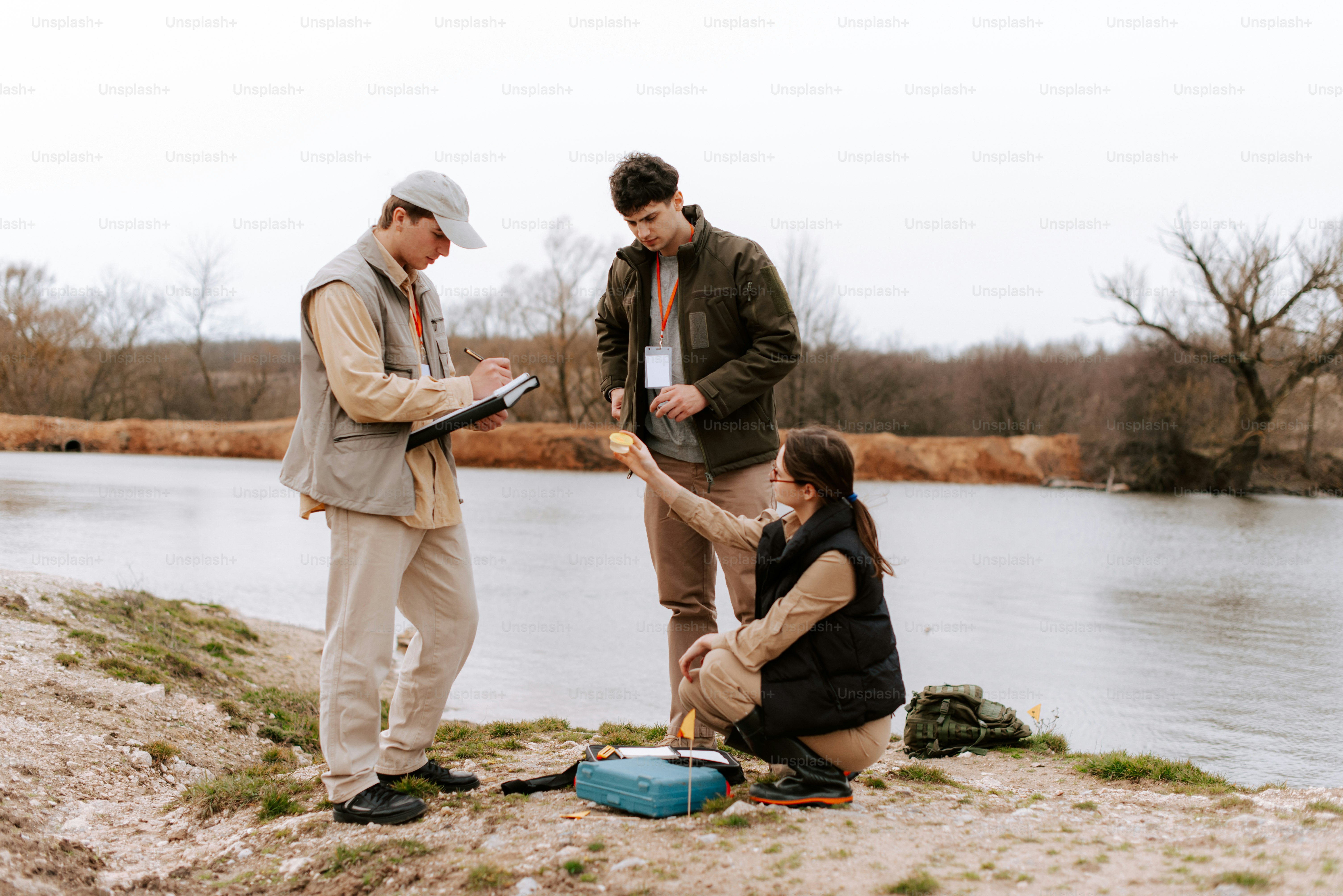 두 남자와 한 여자가 물가에 서 있다