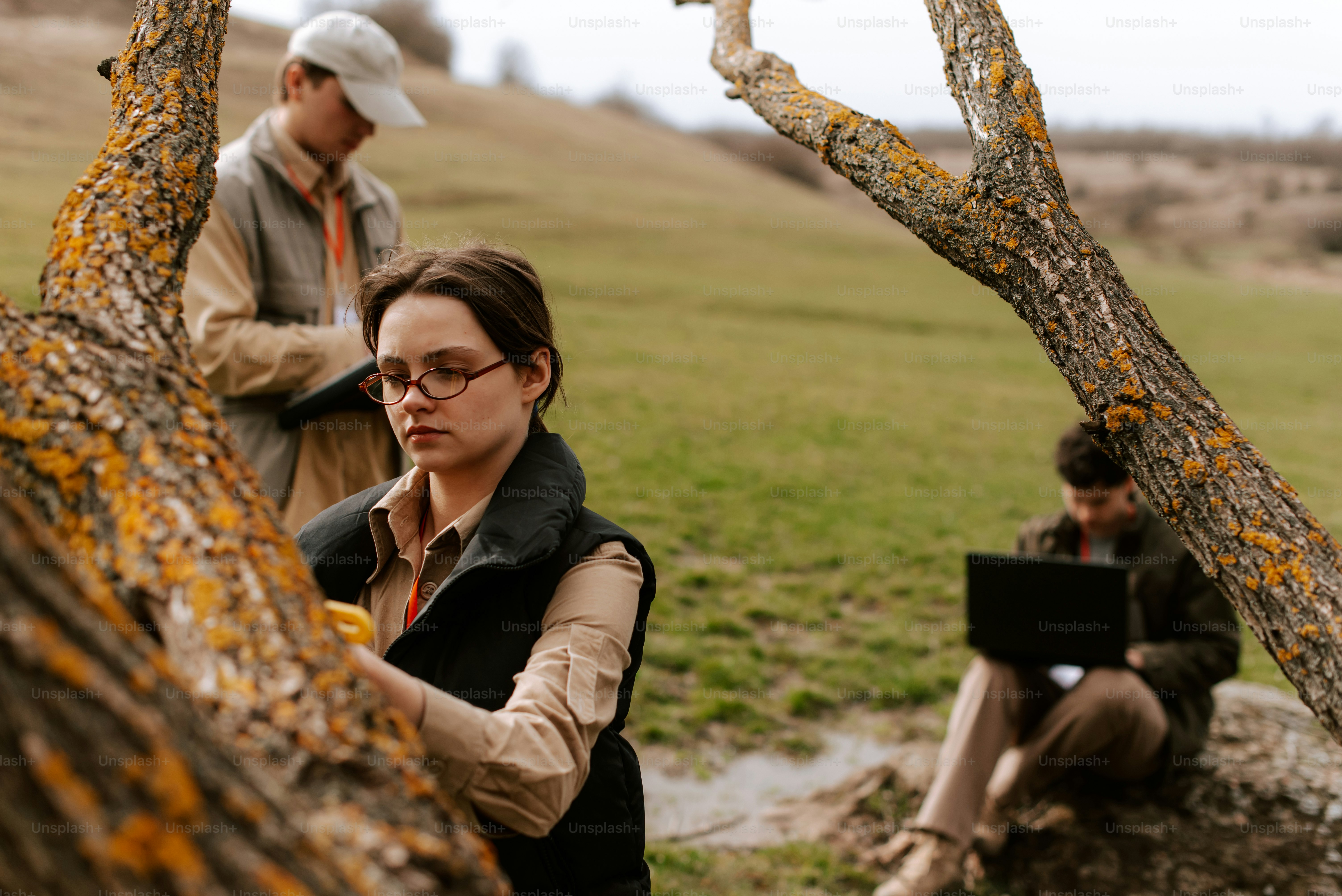 나무 옆에 앉아있는 남자와 여자