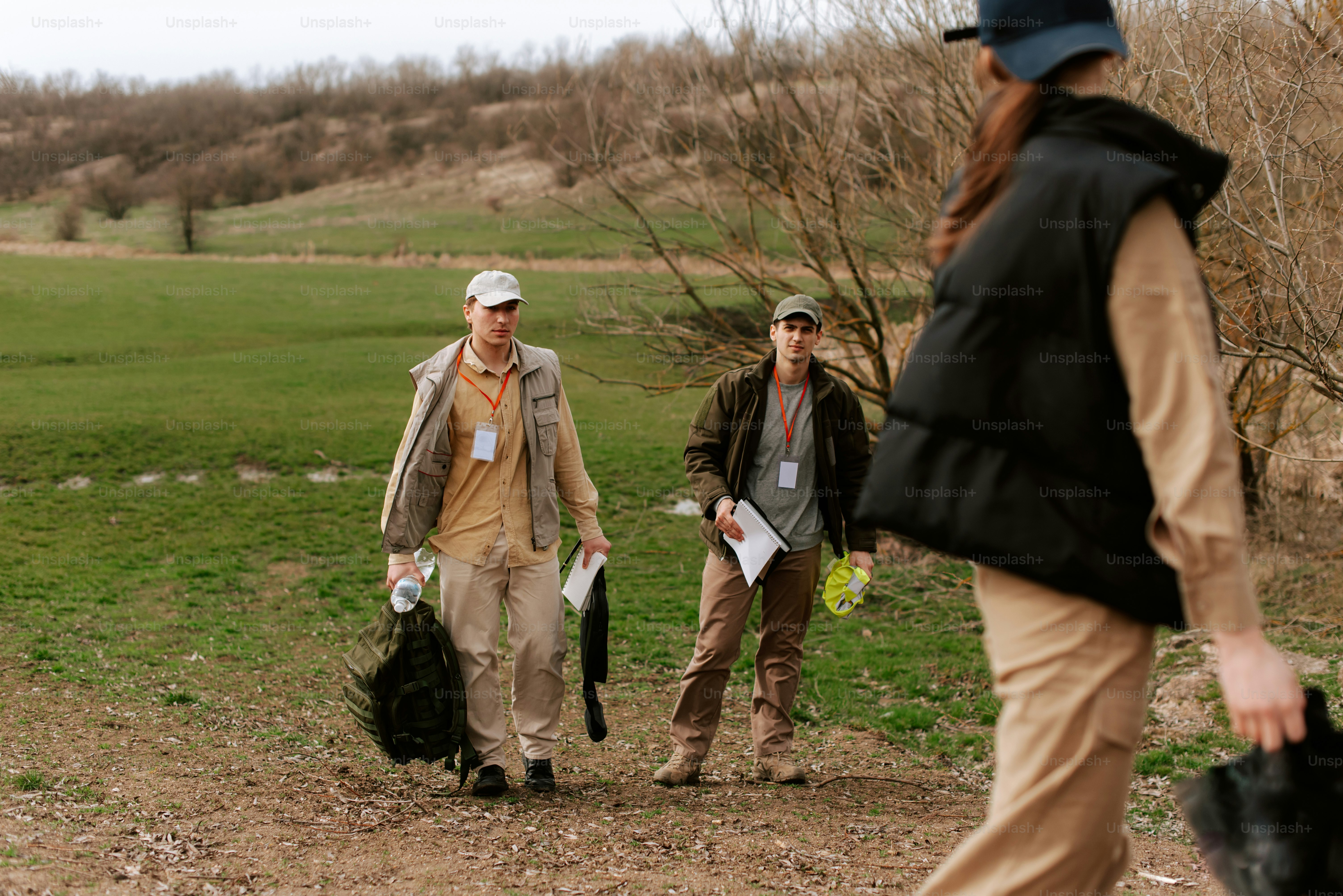 무성한 녹색 들판을 가로질러 걷는 한 무리의 사람들