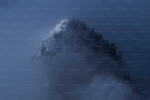 Ein sehr hoher Berg, der in Nebel und Wolken gehüllt ist