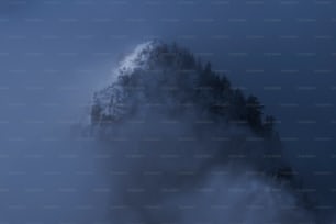 a very tall mountain covered in fog and clouds