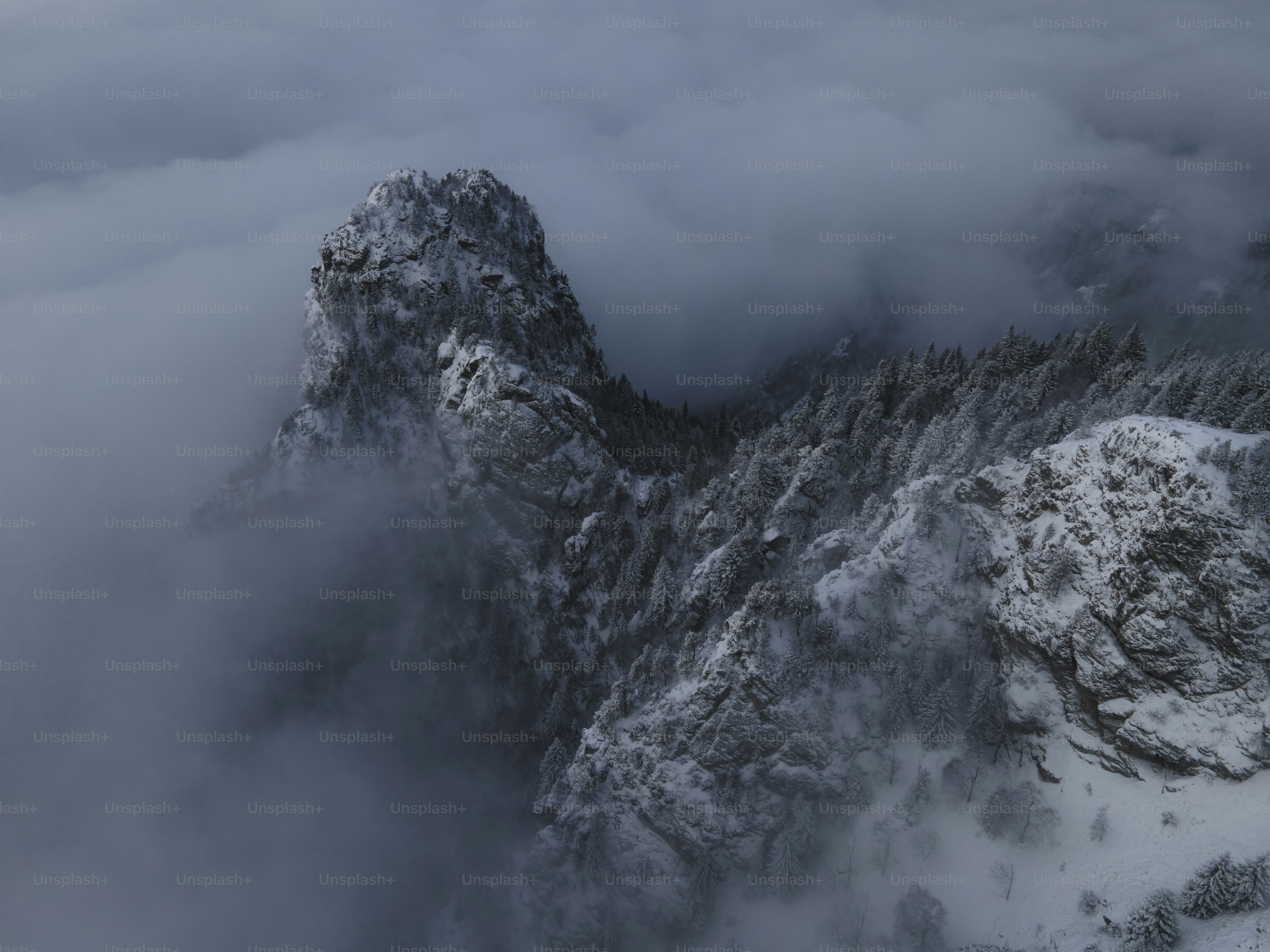 uma montanha coberta de neve cercada por nuvens