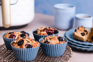 a table topped with blueberry muffins next to a plate of cake