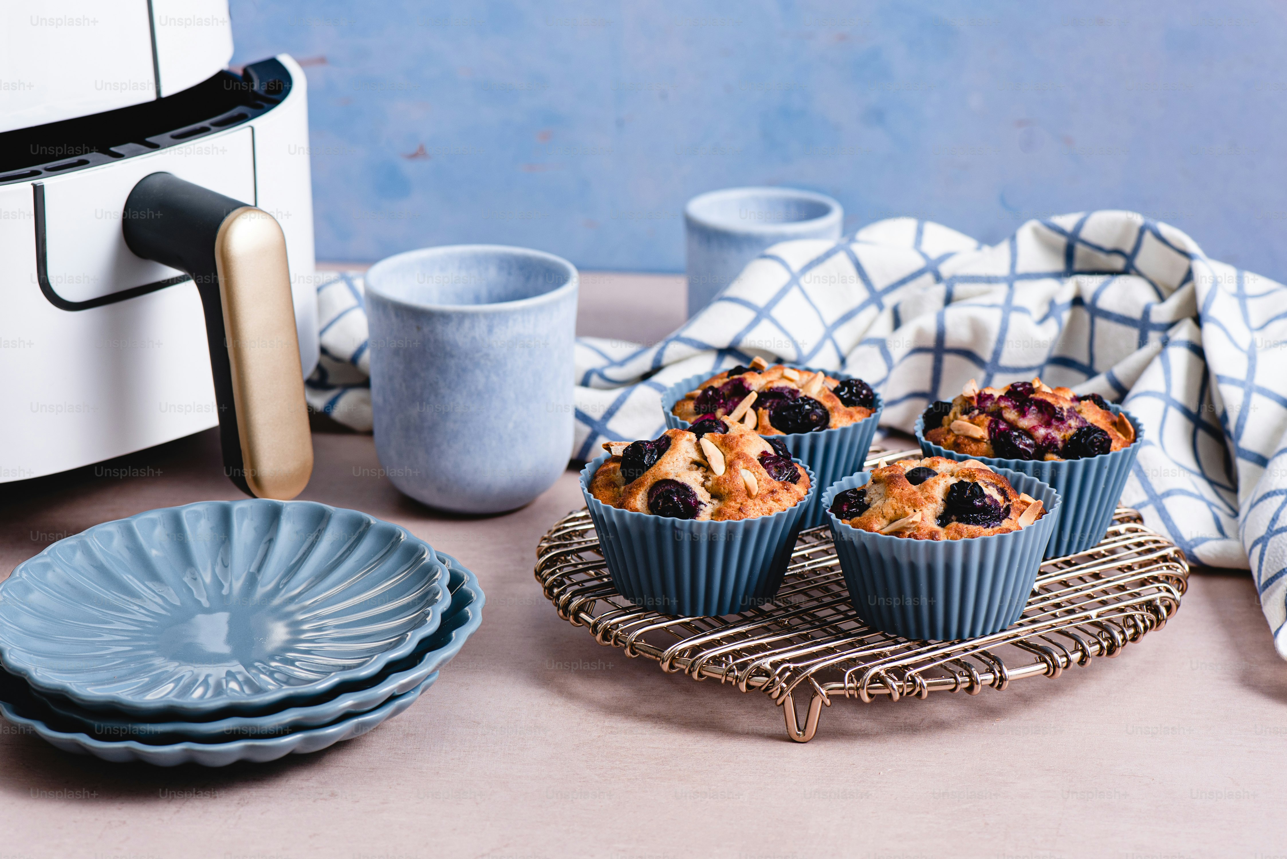 a plate of blueberry muffins next to a toaster