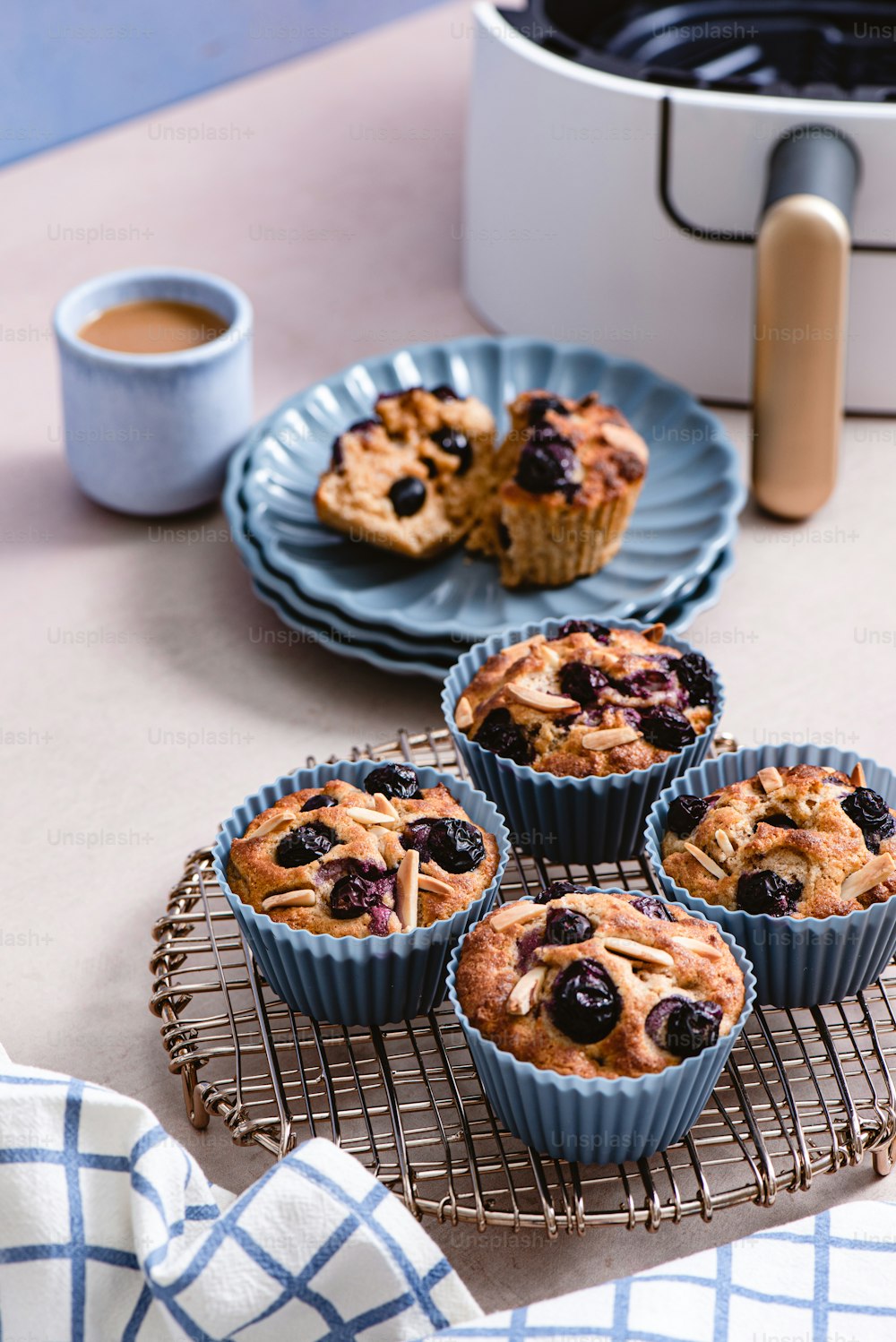 un tavolo sormontato da muffin ai mirtilli accanto a una tazza di caffè