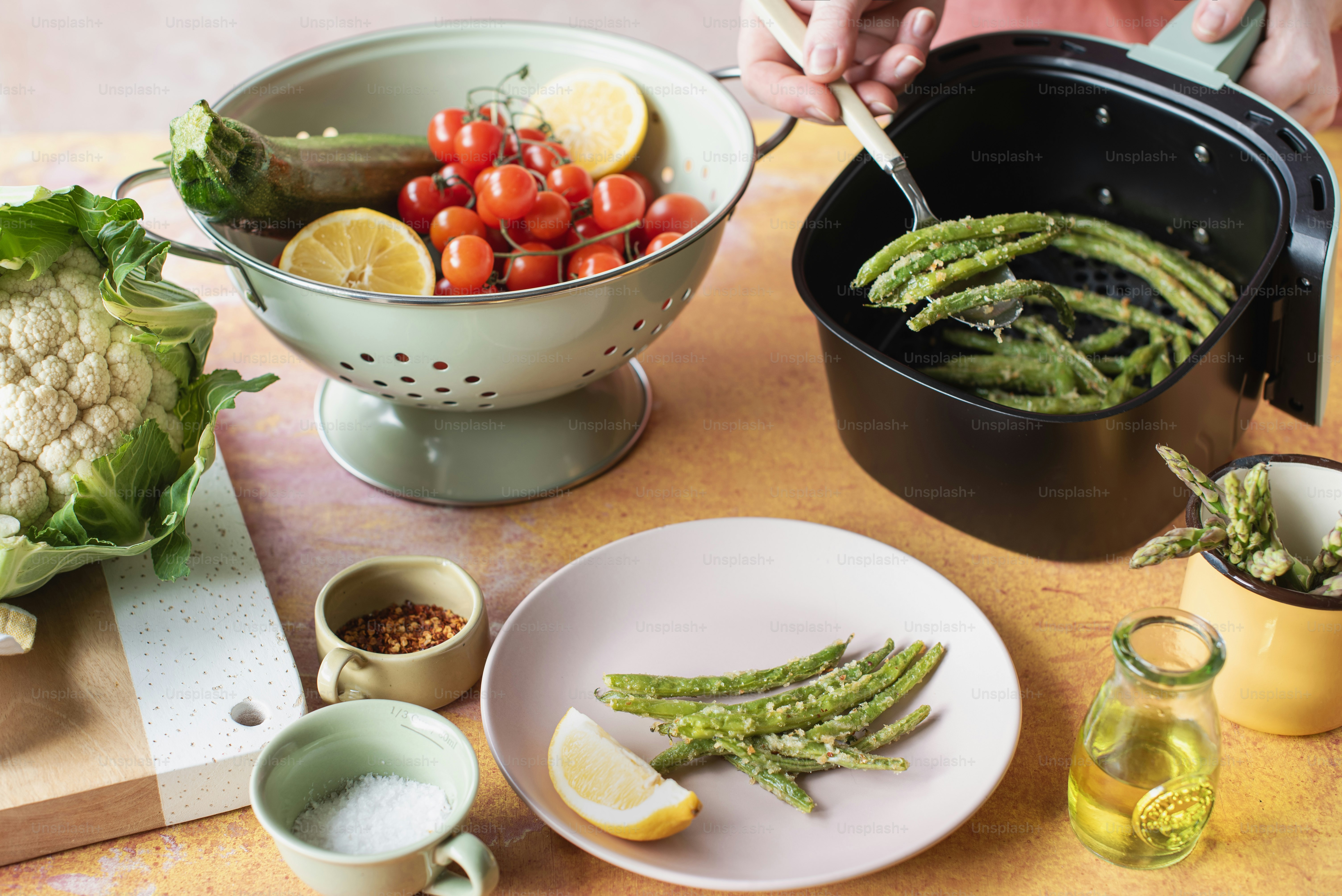 a table topped with plates of food and a bowl of vegetables