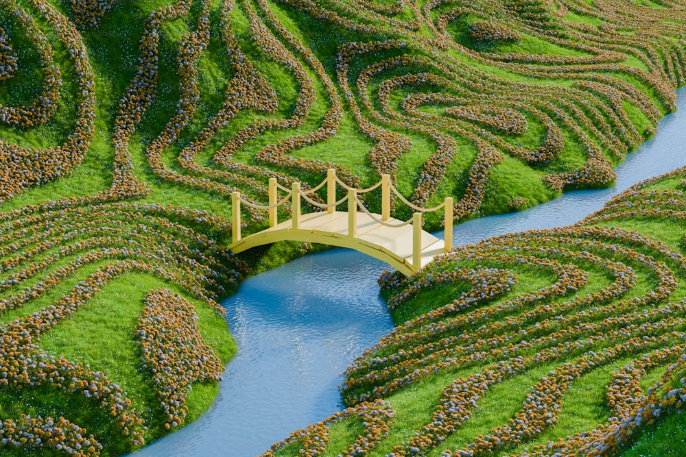 a bridge over a river surrounded by a lush green field