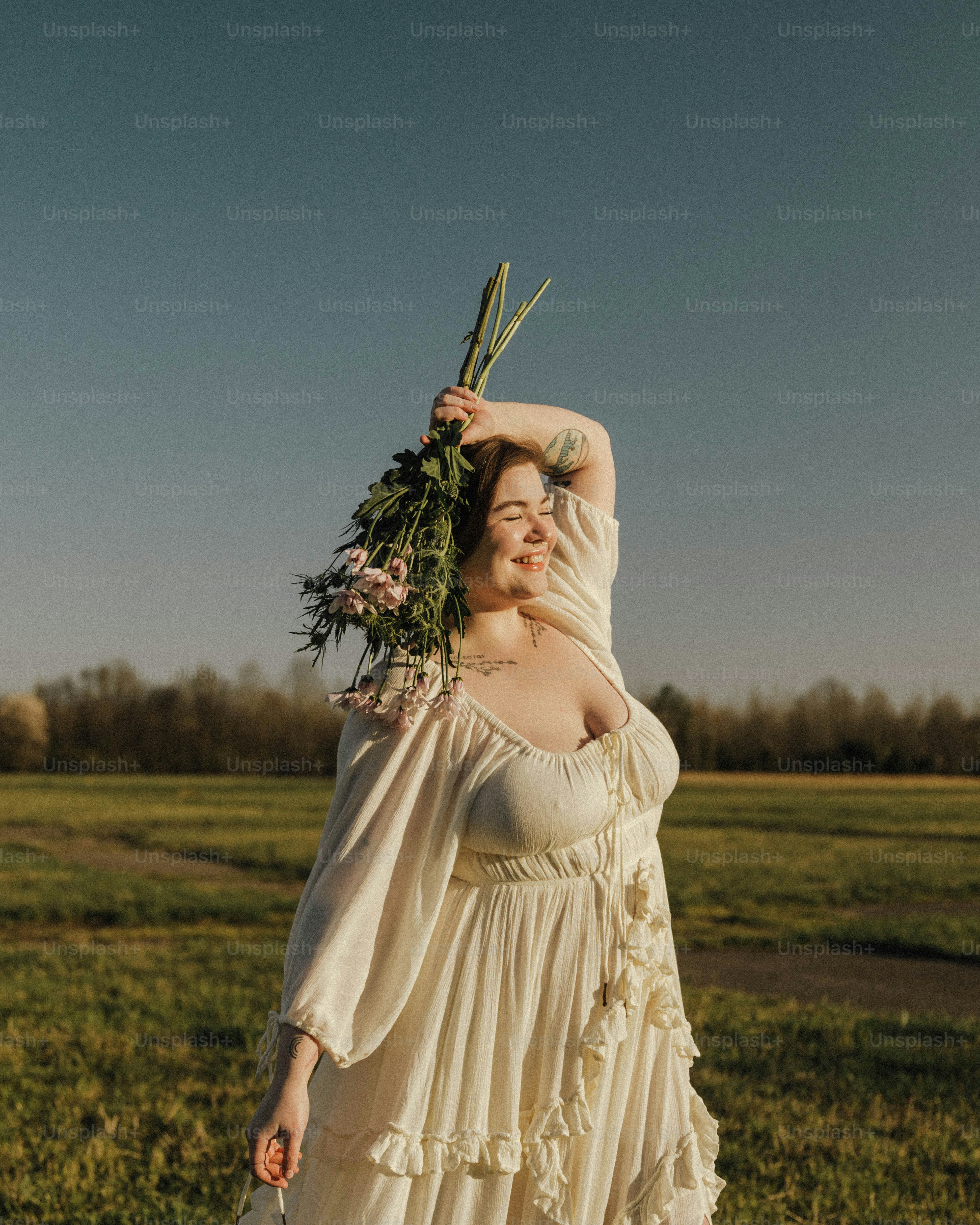 a woman in a white dress holding a bunch of flowers