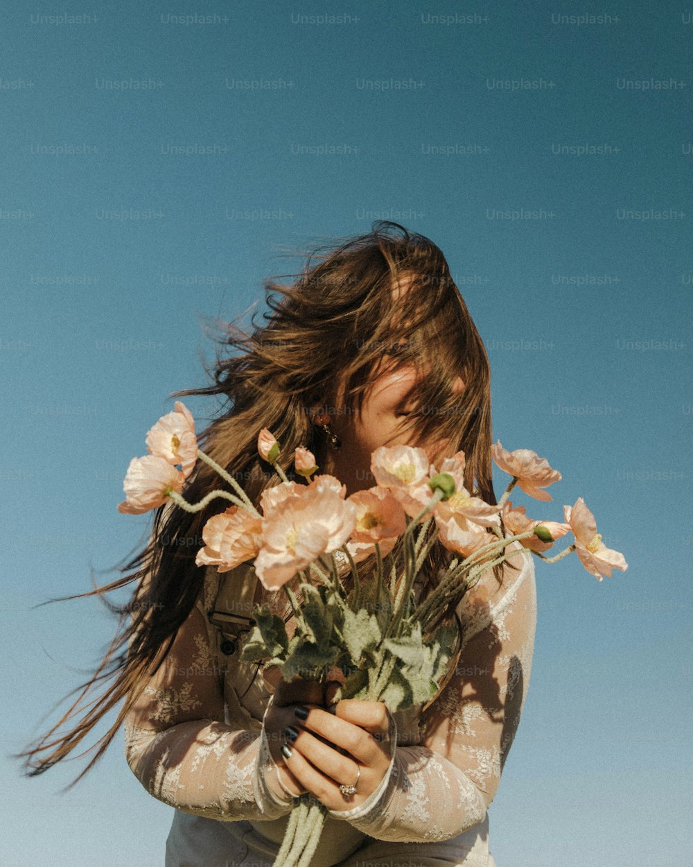 a woman holding a bunch of flowers in her hands