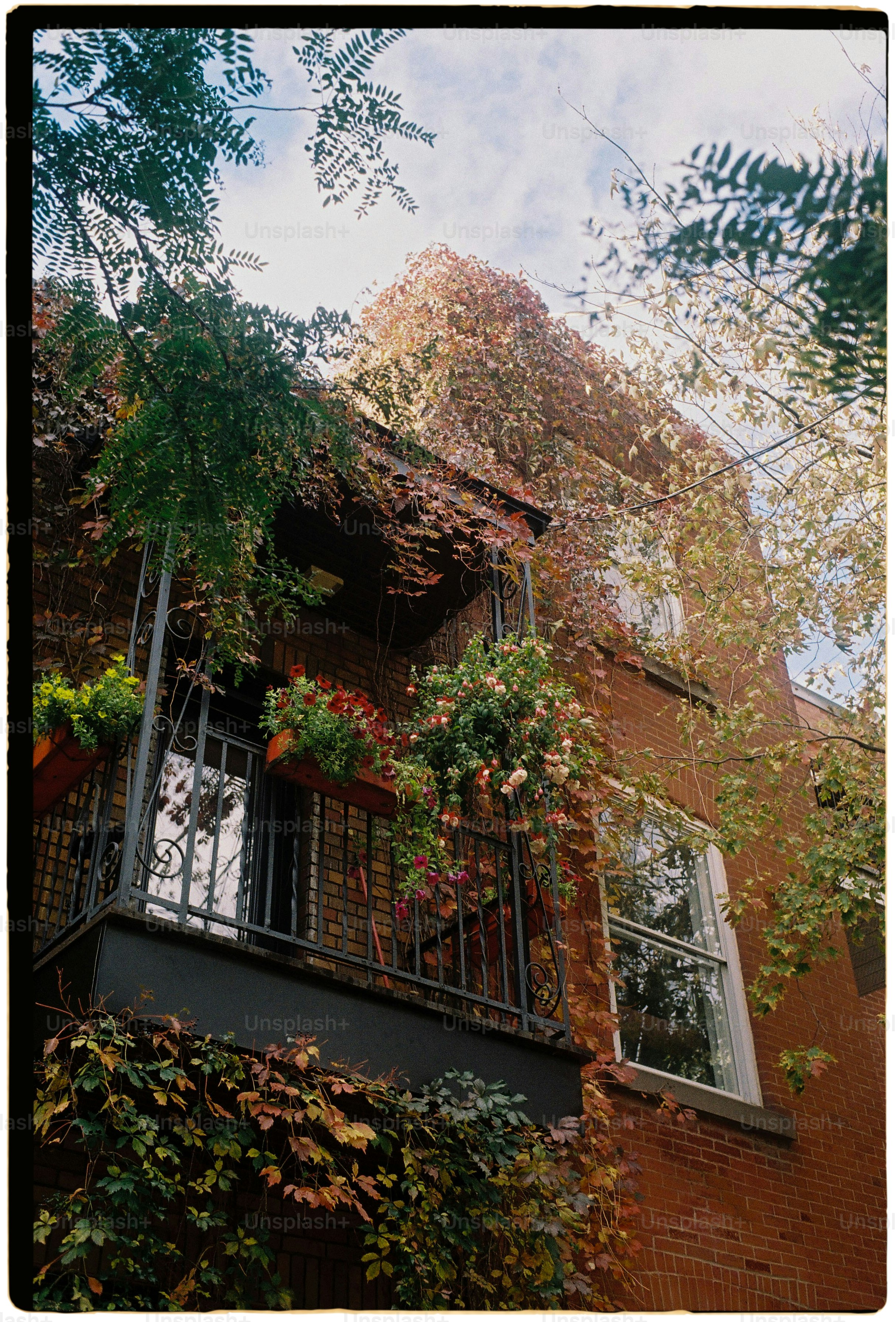a tall building with lots of plants growing on it's balconies