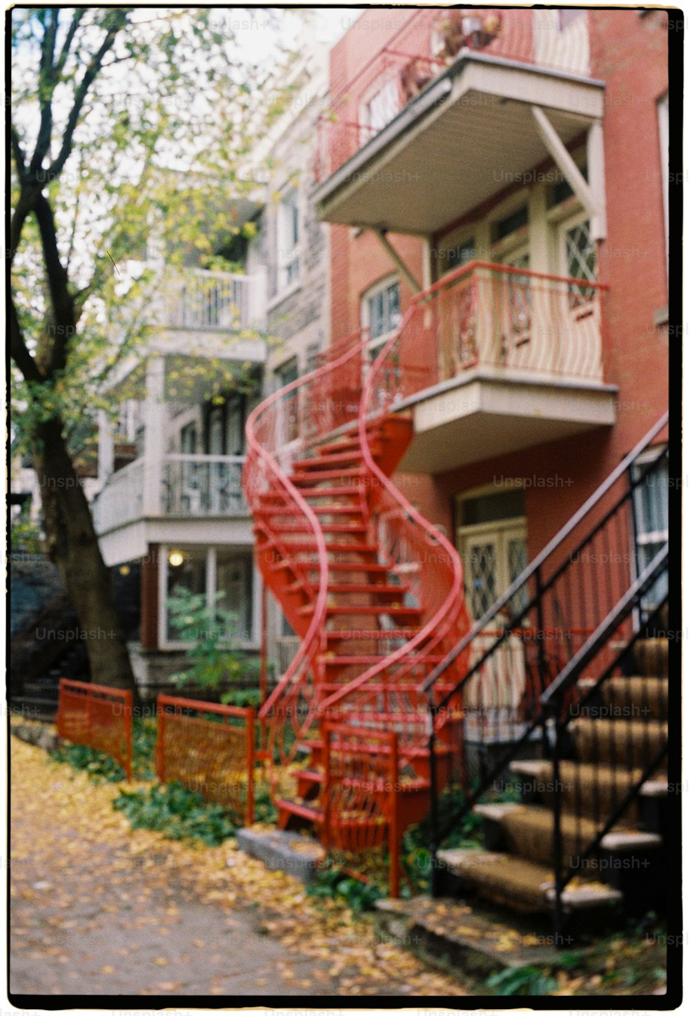 a red spiral staircase in front of a red brick building