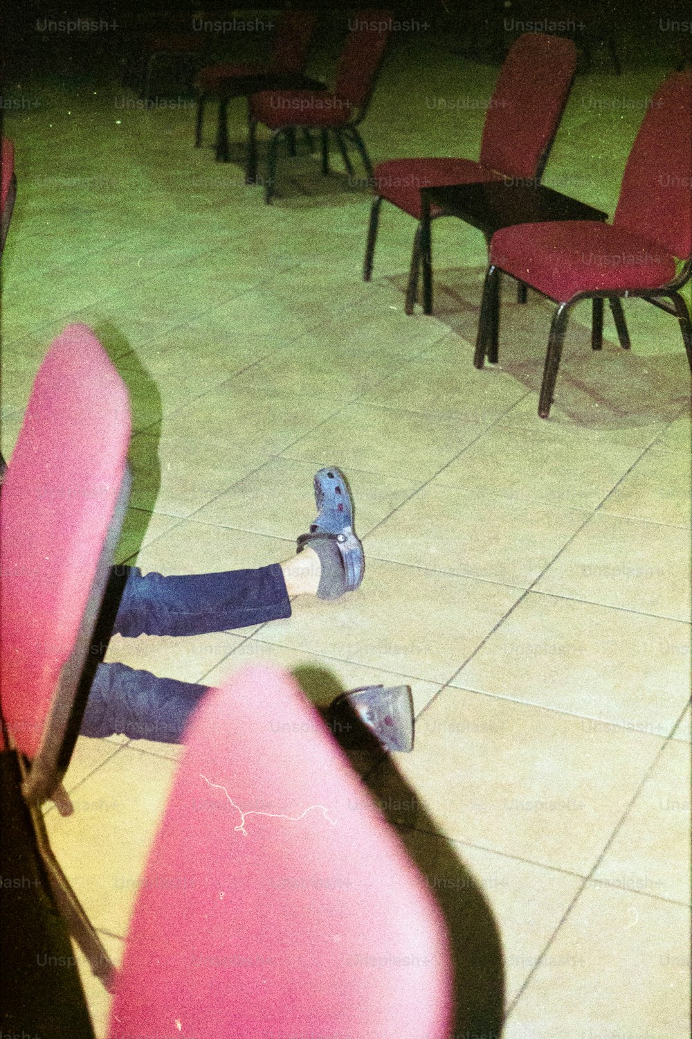 une personne allongée sur le sol, les pieds sur une chaise ;