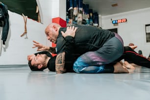 two men are wrestling in a gym