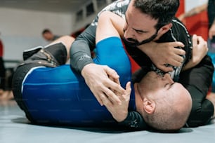 un uomo che lotta con un altro uomo su un ring di wrestling