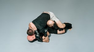 Dos hombres en blanco y negro peleando sobre un fondo gris