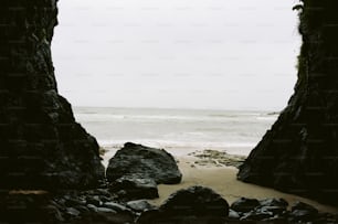 a view of the ocean through two rocks