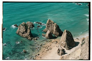 Una veduta aerea di una spiaggia con rocce nell'acqua